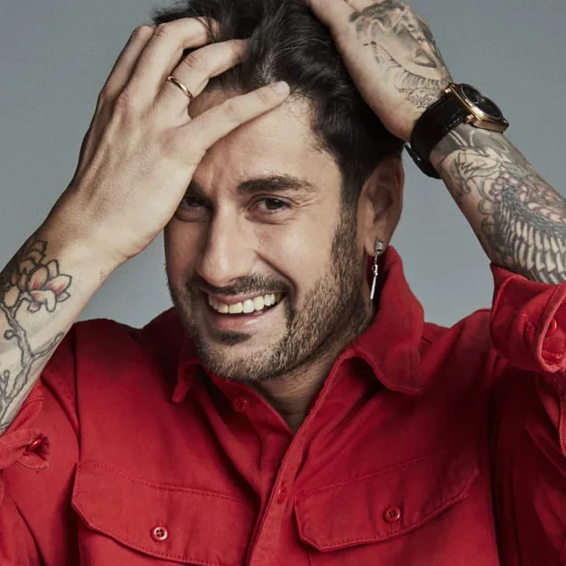 Melen en 2021 con camisa roja y las manos en el pelo